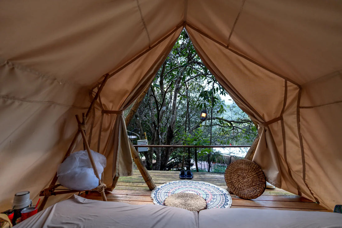 Ruhiges Zeltinneres mit gemütlichem Bett am Waldrand, Symbolbild für die Pflege von Naturmaterial Schlafsäcken beim Camping