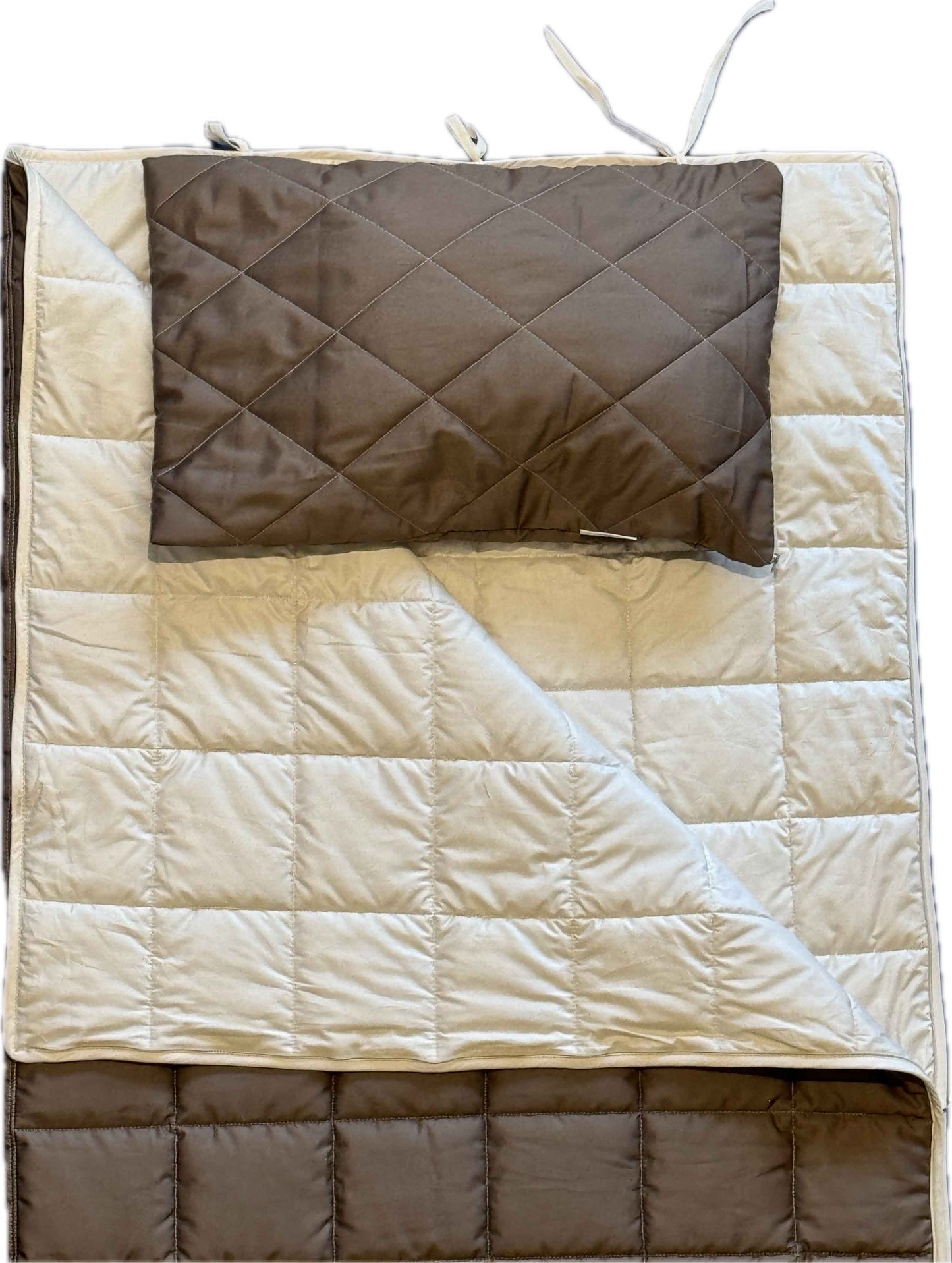 Die Kissenhülle „Essential“ besteht aus einer gesteppten, beige-braunen Unterlage und einem dazu passenden braunen, wärmeisolierenden orthopädischen Reisekissen. Beide sind mit Rauten- und Quadratmustern gesteppt; die Unterlage verfügt über Befestigungsschlaufen an den Ecken und ist teilweise gefaltet, sodass beide Seiten sichtbar sind.