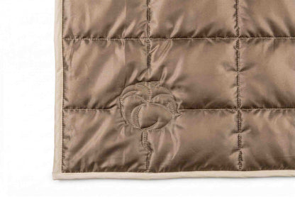 Nahaufnahme einer Ecke des Origobag Essential Baumwolle-Schlafsacks aus brauner, gesteppter Baumwolle mit kreisförmigem Stichmuster und beiger Einfassung – ideal zum Campen und aus nachhaltigen Materialien gefertigt.